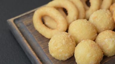 Yiyecek, tavuk nugget, soğan halkaları ve arka planda peynir topları. Fast food, sağlıksız yaşam tarzı