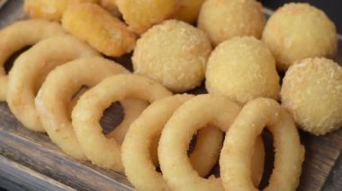 Yiyecek, tavuk nugget, soğan halkaları ve arka planda peynir topları. Fast food, sağlıksız yaşam tarzı