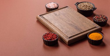 Tek renkli kahverengi arka planda boş ahşap kesim tahtası. Yemek masasında çatal bıçak takımı olan boş bir tahta.