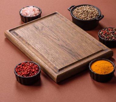 Tek renkli kahverengi arka planda boş ahşap kesim tahtası. Yemek masasında çatal bıçak takımı olan boş bir tahta.