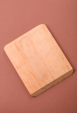 Tek renkli kahverengi arka planda boş ahşap kesim tahtası. Yemek masasında çatal bıçak takımı olan boş bir tahta.