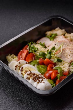 İçinde tavuk, parmesan peyniri, domates, kızarmış ekmek, marul yaprağı, keten tohumu, ayçiçeği ve susam tohumları olan bir kâse dolusu sezar salatası.