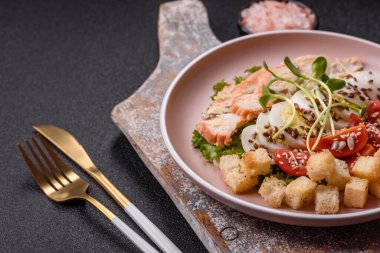 İçinde tavuk, parmesan peyniri, domates, kızarmış ekmek, marul yaprağı, keten tohumu, ayçiçeği ve susam tohumları olan bir kâse dolusu sezar salatası.