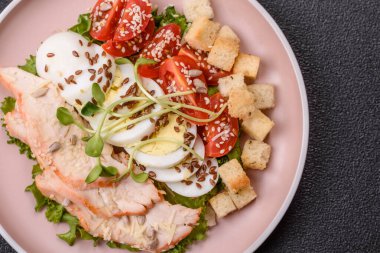 İçinde tavuk, parmesan peyniri, domates, kızarmış ekmek, marul yaprağı, keten tohumu, ayçiçeği ve susam tohumları olan bir kâse dolusu sezar salatası.