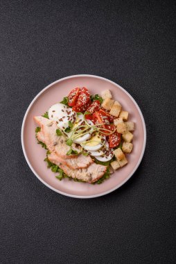 İçinde tavuk, parmesan peyniri, domates, kızarmış ekmek, marul yaprağı, keten tohumu, ayçiçeği ve susam tohumları olan bir kâse dolusu sezar salatası.