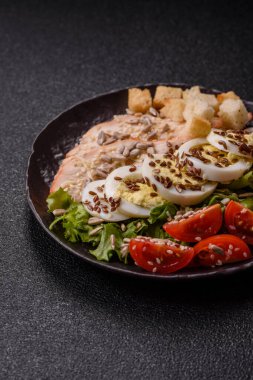 İçinde tavuk, parmesan peyniri, domates, kızarmış ekmek, marul yaprağı, keten tohumu, ayçiçeği ve susam tohumları olan bir kâse dolusu sezar salatası.