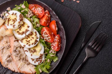 İçinde tavuk, parmesan peyniri, domates, kızarmış ekmek, marul yaprağı, keten tohumu, ayçiçeği ve susam tohumları olan bir kâse dolusu sezar salatası.