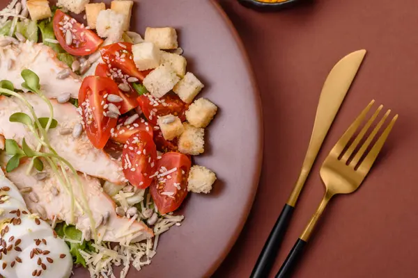 İçinde tavuk, parmesan peyniri, domates, kızarmış ekmek, marul yaprağı, keten tohumu, ayçiçeği ve susam tohumları olan bir kâse dolusu sezar salatası.