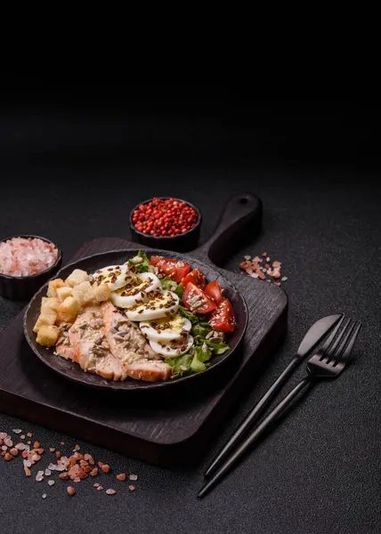 İçinde tavuk, parmesan peyniri, domates, kızarmış ekmek, marul yaprağı, keten tohumu, ayçiçeği ve susam tohumları olan bir kâse dolusu sezar salatası.