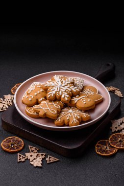 Noel kış zencefilli ekmeği, tek renkli arka planda bayram bisküvileri. Masada zencefilli çörekler