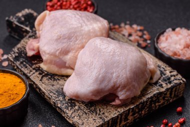 Tek renkli arka planda tuz ve baharatlı taze tavuk budu eti.