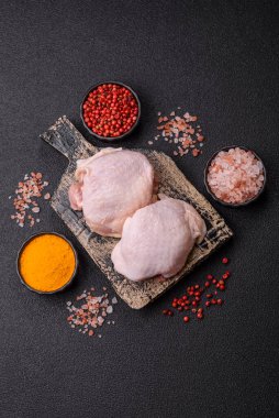 Tek renkli arka planda tuz ve baharatlı taze tavuk budu eti.