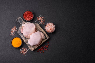 Tek renkli arka planda tuz ve baharatlı taze tavuk budu eti.