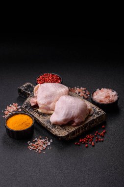 Tek renkli arka planda tuz ve baharatlı taze tavuk budu eti.