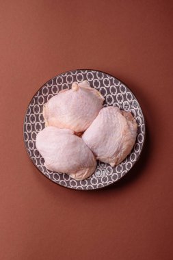 Tek renkli arka planda tuz ve baharatlı taze tavuk budu eti.