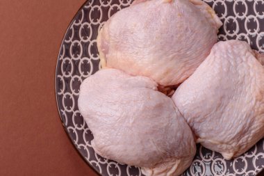 Tek renkli arka planda tuz ve baharatlı taze tavuk budu eti.