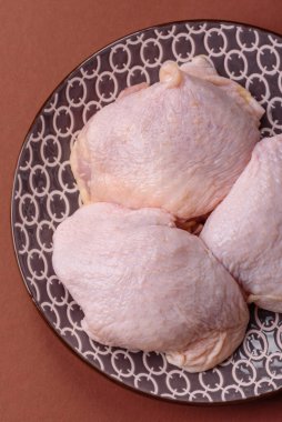 Tek renkli arka planda tuz ve baharatlı taze tavuk budu eti.