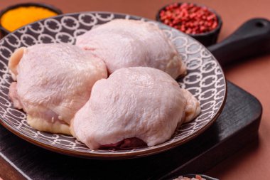 Tek renkli arka planda tuz ve baharatlı taze tavuk budu eti.