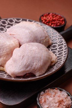 Tek renkli arka planda tuz ve baharatlı taze tavuk budu eti.