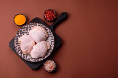 Tek renkli arka planda tuz ve baharatlı taze tavuk budu eti.