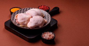 Tek renkli arka planda tuz ve baharatlı taze tavuk budu eti.