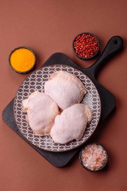 Tek renkli arka planda tuz ve baharatlı taze tavuk budu eti.