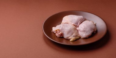 Tek renkli arka planda tuz ve baharatlı taze tavuk budu eti.