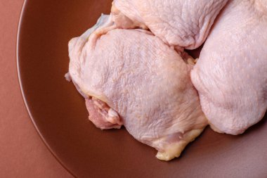 Tek renkli arka planda tuz ve baharatlı taze tavuk budu eti.