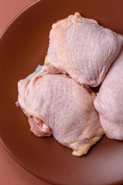 Tek renkli arka planda tuz ve baharatlı taze tavuk budu eti.