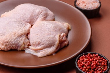 Tek renkli arka planda tuz ve baharatlı taze tavuk budu eti.