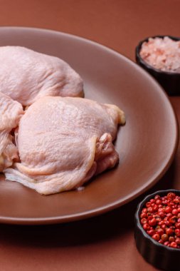 Tek renkli arka planda tuz ve baharatlı taze tavuk budu eti.