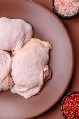 Tek renkli arka planda tuz ve baharatlı taze tavuk budu eti.