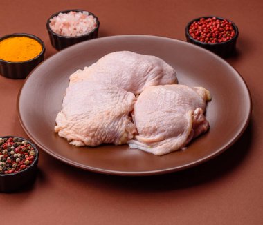 Tek renkli arka planda tuz ve baharatlı taze tavuk budu eti.