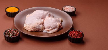 Tek renkli arka planda tuz ve baharatlı taze tavuk budu eti.