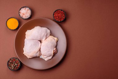 Tek renkli arka planda tuz ve baharatlı taze tavuk budu eti.