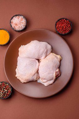 Tek renkli arka planda tuz ve baharatlı taze tavuk budu eti.