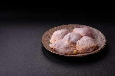 Tek renkli arka planda tuz ve baharatlı taze tavuk budu eti.