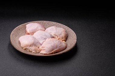 Tek renkli arka planda tuz ve baharatlı taze tavuk budu eti.