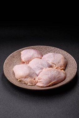 Tek renkli arka planda tuz ve baharatlı taze tavuk budu eti.