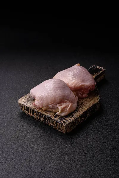 Tek renkli arka planda tuz ve baharatlı taze tavuk budu eti.