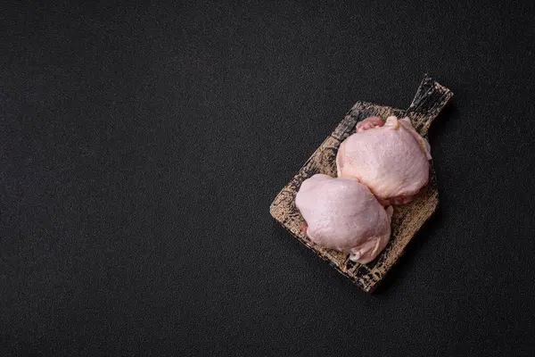 Tek renkli arka planda tuz ve baharatlı taze tavuk budu eti.