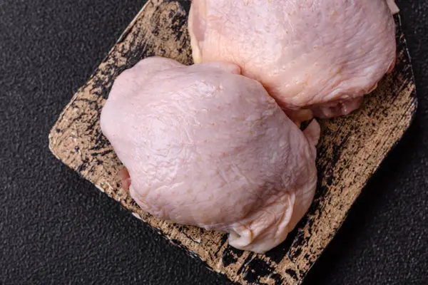 Tek renkli arka planda tuz ve baharatlı taze tavuk budu eti.