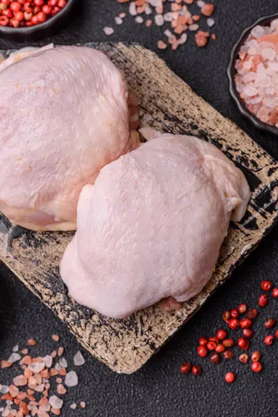 Tek renkli arka planda tuz ve baharatlı taze tavuk budu eti.