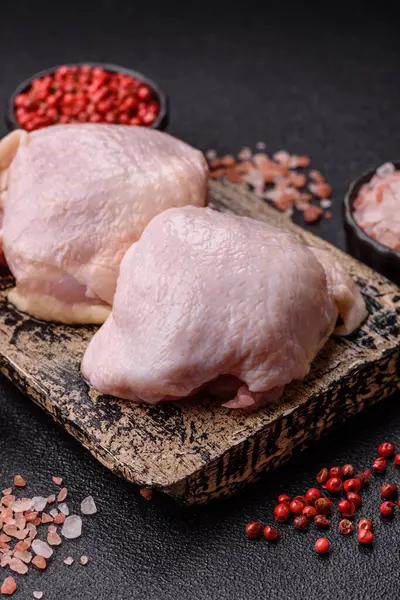 Tek renkli arka planda tuz ve baharatlı taze tavuk budu eti.