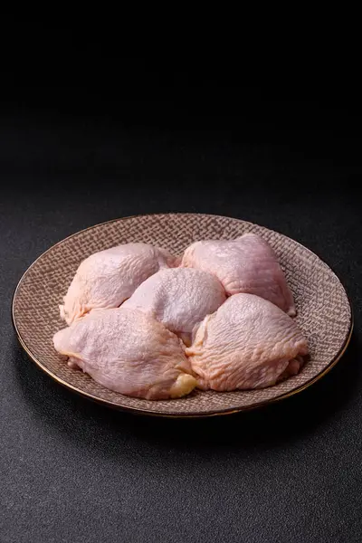 Tek renkli arka planda tuz ve baharatlı taze tavuk budu eti.