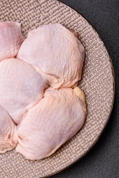 Tek renkli arka planda tuz ve baharatlı taze tavuk budu eti.