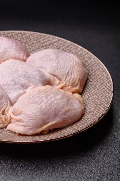 Tek renkli arka planda tuz ve baharatlı taze tavuk budu eti.