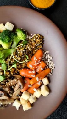 Tofulu yemek kasesi, kinoa, brokoli ve havuç, mikroyeşiller, keten ve ayçiçeği tohumları.