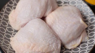 Tek renkli arka planda tuz ve baharatlı taze tavuk budu eti.