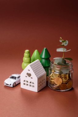 Tasarruf ve mali yatırım kavramı olarak bir kavanozda madeni para ve bitki. Parayla dolu cam bir kavanozda yeşil dal
